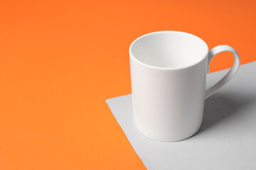 One white ceramic mug on color background, space for text