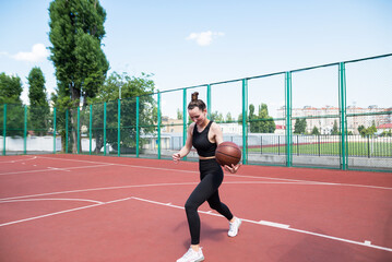 Obraz premium Athletic basketball player dribbles the ball on the basketball field.