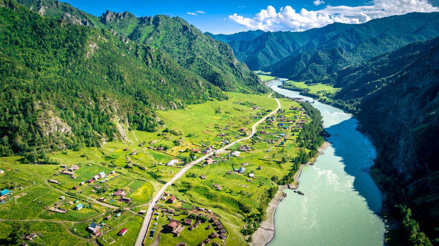 View of the Katun river in the Altai near Chemal. Mountain valley Che-Chkysh. Summer landscape. Turquoise river, mountains and green meadows