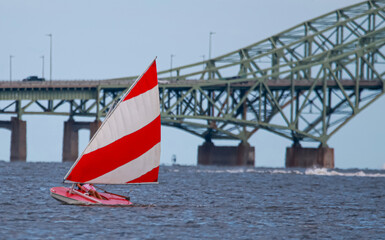 Sunfish sailboat sailing by the Great South Bay Bridge