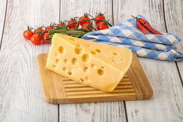 Maasdam cheese piece over board
