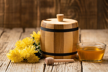 Honey in a small barrel and a bowl on a rustic background.