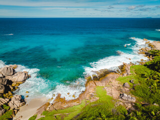 Aerial view Top down seashore. Waves crashing on rock cliff. Beautiful dark sea surface in sunny day summer background Amazing seascape top view seacoast at La Dique Grand l'Anse, Seychelles