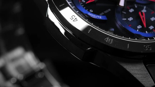 Man Wrist Watch With Moving And Multiple Dials. Men's chronograph watch in metal with sapphire crystal. Closeup view of rotating watch, running second arrow. Watch with blue dial