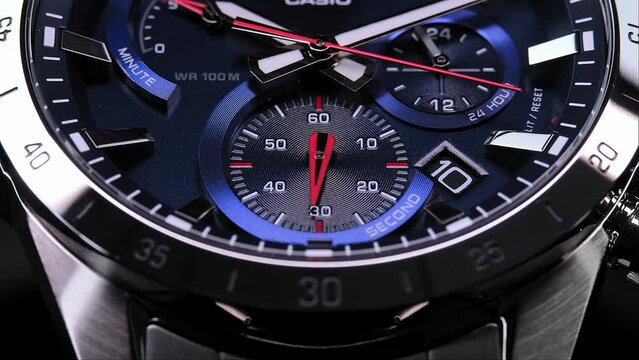Man Wrist Watch With Moving And Multiple Dials. Men's chronograph watch in metal with sapphire crystal. Closeup view of rotating watch, running second arrow. Watch with blue dial