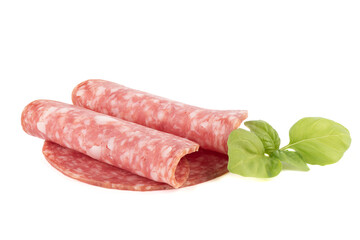 Sliced delicious raw smoked sausage and green basil leaves on a white background.