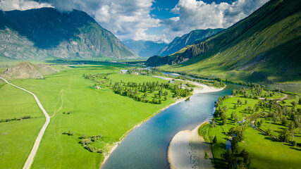 Summer landscape in the Chulyshman mountain valley. Winding mountain river, green alpine meadows...