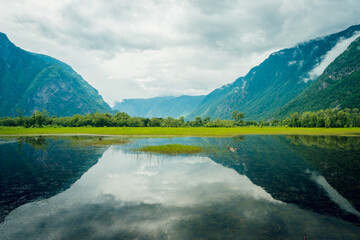 Fototapeta na wymiar Cape Kyrsai on Lake Teletskoye in the Altai Mountains. Summer landscape in the mountains near a mountain lake