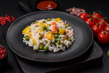 Delicious fresh white boiled rice with vegetables carrots, peppers and asparagus beans on a ceramic plate