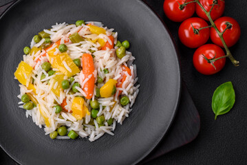 Delicious fresh white boiled rice with vegetables carrots, peppers and asparagus beans on a ceramic plate