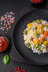 Delicious fresh white boiled rice with vegetables carrots, peppers and asparagus beans on a ceramic plate