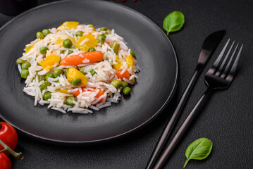 Delicious fresh white boiled rice with vegetables carrots, peppers and asparagus beans on a ceramic plate