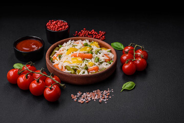 Delicious fresh white boiled rice with vegetables carrots, peppers and asparagus beans on a ceramic plate