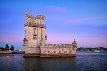 Belem Tower or Tower of St Vincent - famous tourist landmark of Lisboa and tourism attraction - on the bank of the Tagus River (Tejo) in evening dusk after sunset with dramatic sky. Lisbon, Portugal