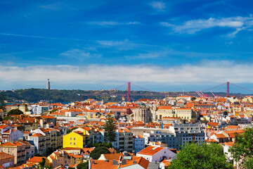 Naklejka na ściany i meble Lisbon famous view from Miradouro dos Barros tourist viewpoint over Alfama old city district, 25th of April Bridge and Christ the King statue. Lisbon, Portugal. With copyspace