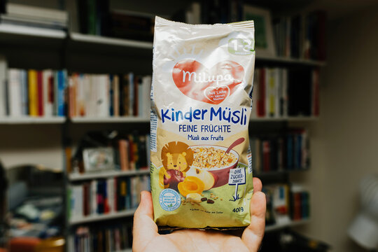 Paris, France - June, 3 2023: Male hand holding package of Milupa Kinder Musli - mix of cereals and diverse fruits