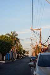 rua de cidade brasileira ao fim da tarde, carros estacionados