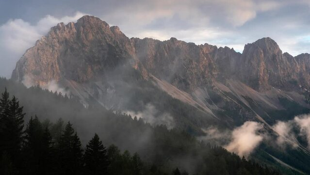 timelapse of moutains during sunset with fog and rainclouds passing over it