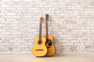 Fototapeta na wymiar Two guitars near brick wall