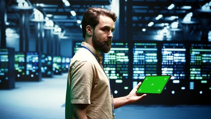Computer scientist using green screen tablet to verify data center configuration settings....