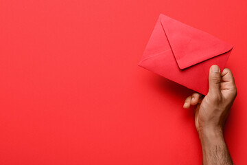 Male hand with envelope on color background