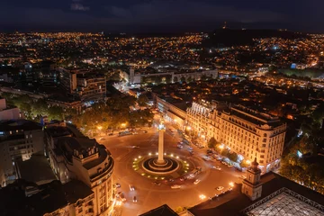 Fotobehang Panoramic night aerial view of Tbilisi, capital of Georgia from drone. Liberty square © Mulderphoto
