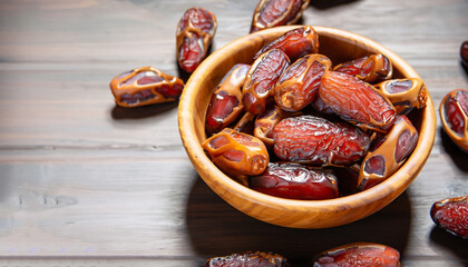 Dates or dattes palm fruit in wooden bowl is snack healthy.