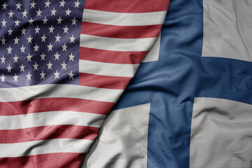 big waving colorful flag of united states of america and national flag of finland .