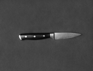 Large kitchen knife on a black background top view