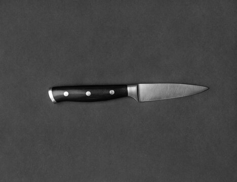 Large kitchen knife on a black background top view
