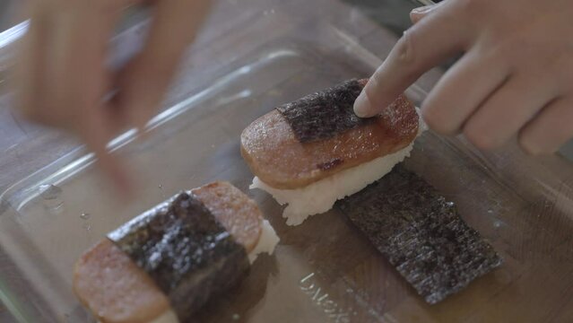 This video shows anonymous hands makes spam masubi.