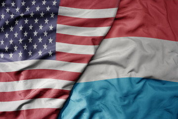 big waving colorful flag of united states of america and national flag of luxembourg .