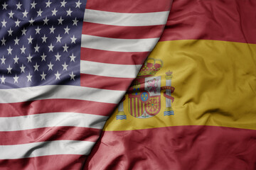 big waving colorful flag of united states of america and national flag of spain .