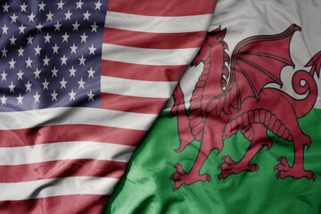 big waving colorful flag of united states of america and national flag of wales .