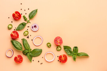 Fresh basil, cherry tomatoes and slices of red onion on orange background