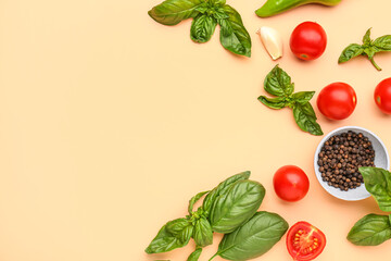 Fresh basil, cherry tomatoes and peppercorn on orange background