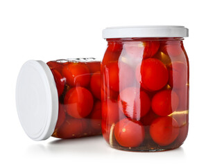 Jars with canned tomatoes on white background