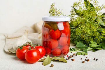 Jar with canned tomatoes and peppercorn on white background