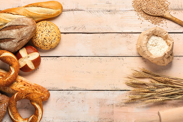 Composition with different types of bread, wheat ears and flour on white wooden table