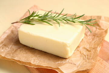 Baking paper with fresh butter and rosemary on yellow background