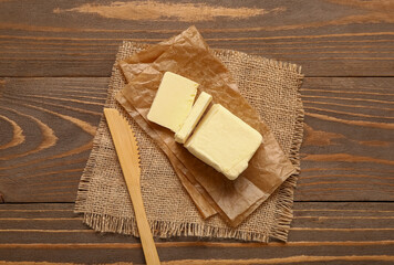 Baking paper with fresh butter on wooden background