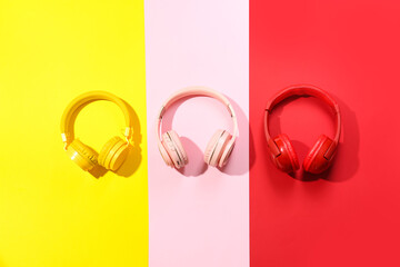 Set of headphones on color background
