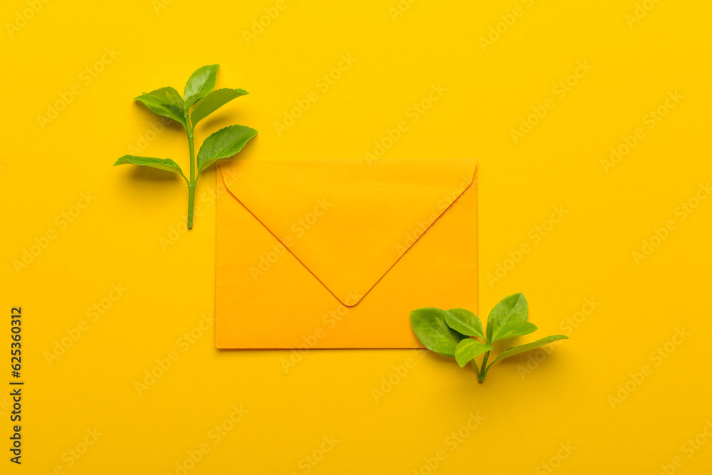 Wall mural Paper envelope with plant branches on yellow branches