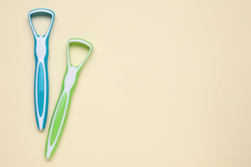 Colorful tongue cleaners on beige background, flat lay. Space for text