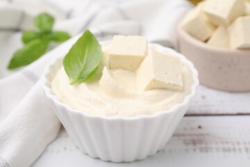 Delicious tofu sauce and basil leaf on white wooden table, closeup