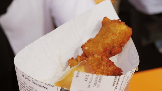 Fried fish and chips in a paper cone on festival market fodd truck. 