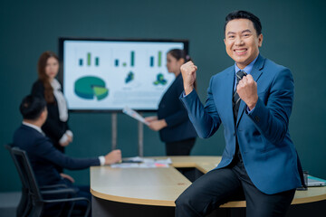 Handsome Asian middle-aged executives business man standing confident in the office in front of his team.