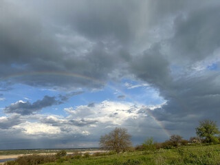 storm clouds and rainbow over the river