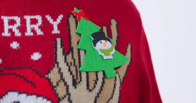Close-up of dog paw sticking Christmas tree sticker on his chest in ugly christmas sweater. Party festive competitions children animation awarding the winners. badge party festive dress code