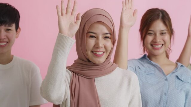 Young adult Gen Z female team group asia people self esteem arm hand raised vote happy smile looking at camera. Asian woman unity power gender equal support islam lady women's day anti racism racial.